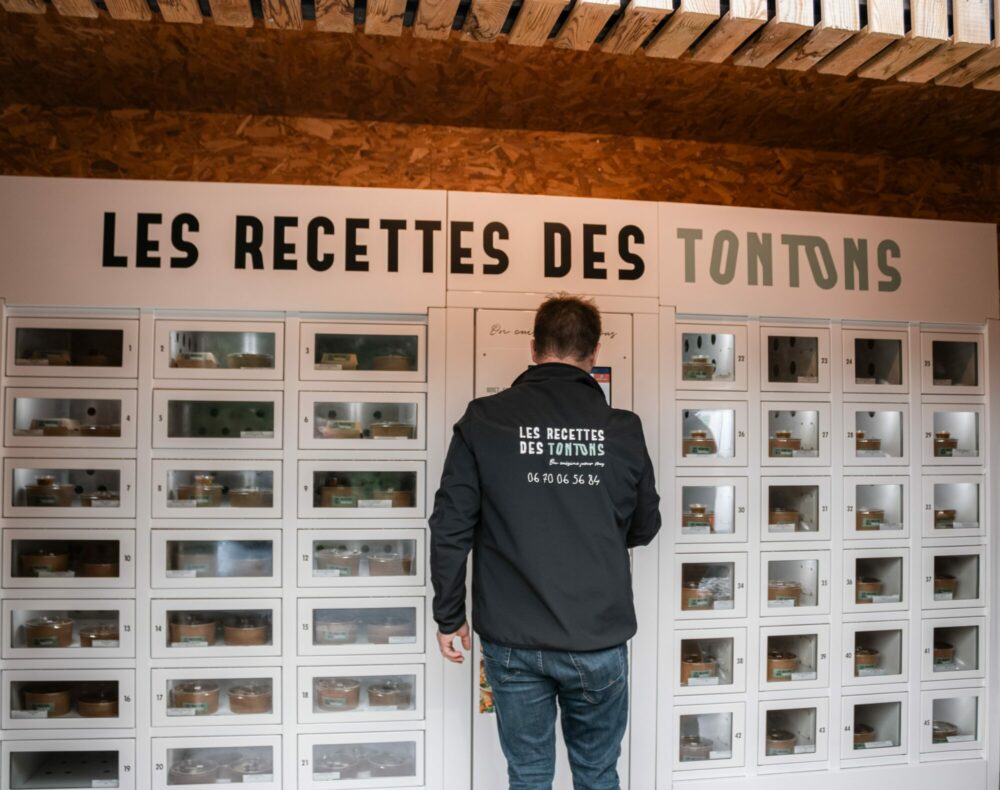 L'un des gérants du distributeur automatique Les recettes des tontons en train de le réaprovisionner